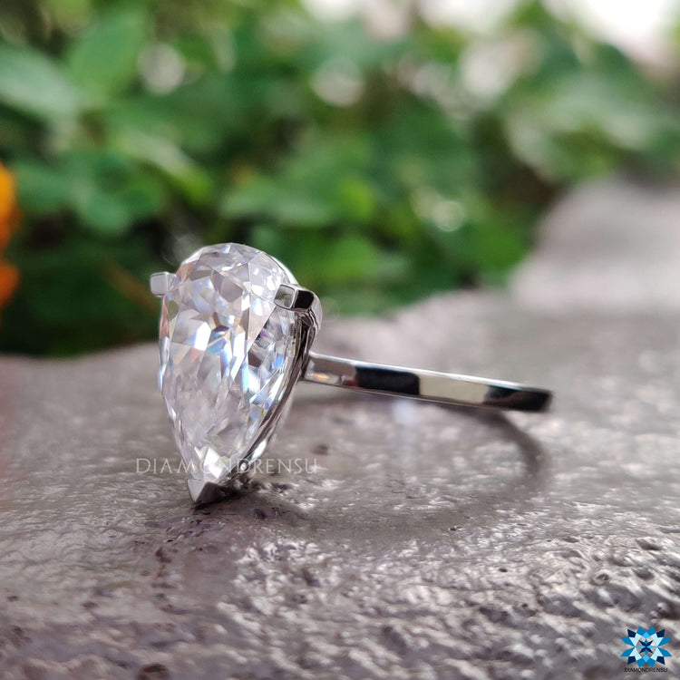 Minimalist moissanite engagement ring with pear cut stone.
