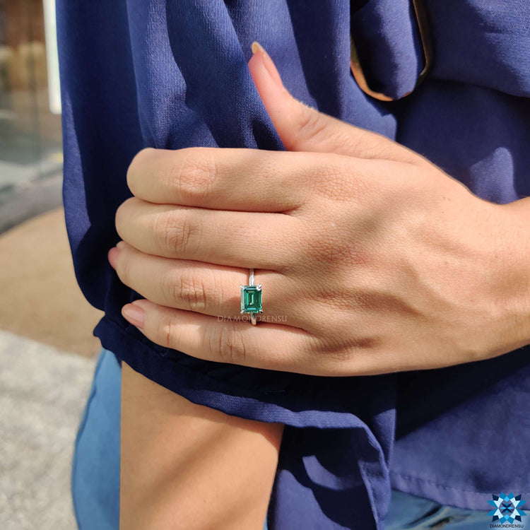 Emerald cut east west ring with white gold band.
