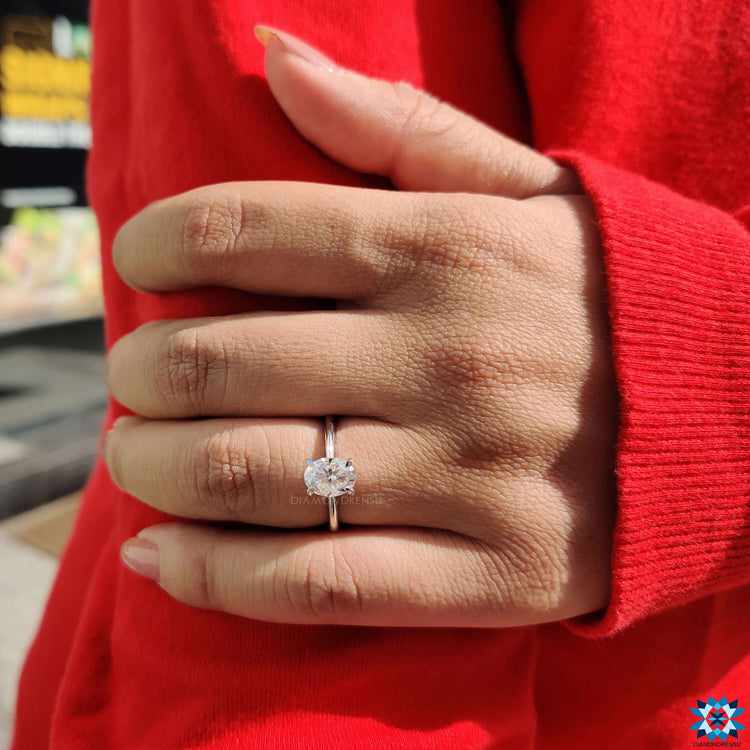 White gold engagement ring featuring an oval cut moissanite center stone.

