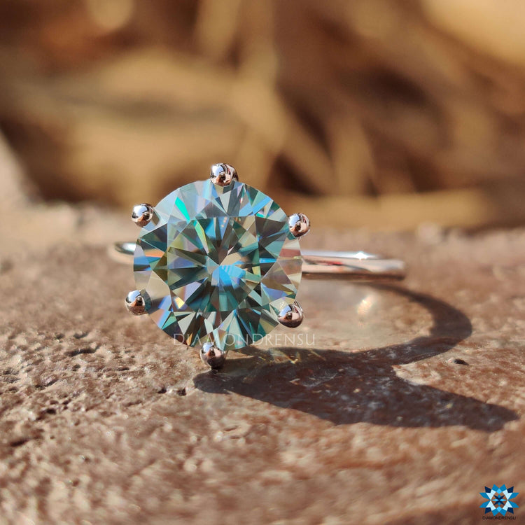 Simple engagement ring design crafted with a round cut moissanite and white gold band.
