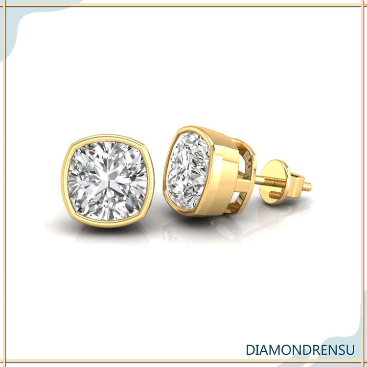 UK diamond earrings with cushion cut stones in bezel setting.
