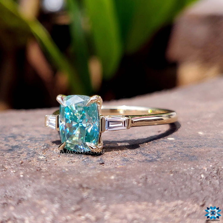 Handmade three stone ring featuring elongated cushion moissanite.
