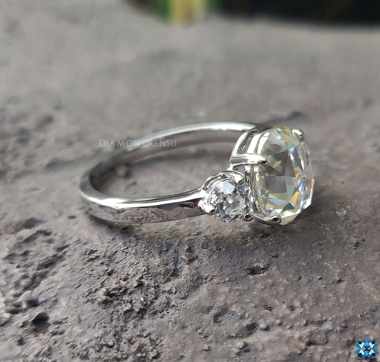 Three stone oval engagement ring featuring sparkling diamonds.
