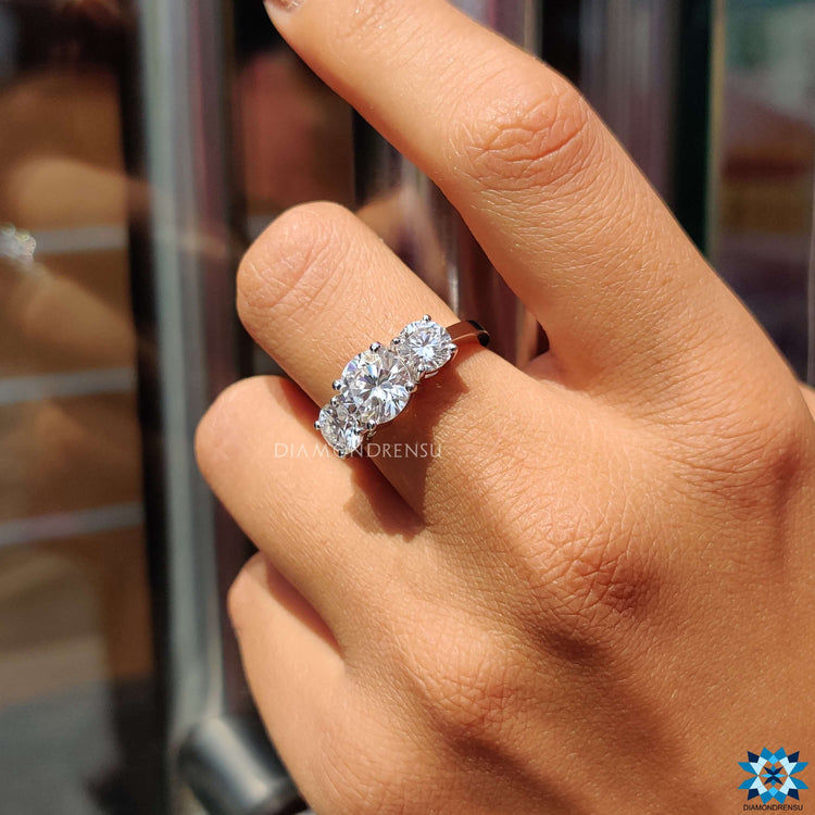 Prong setting ring featuring three moissanite stones.
