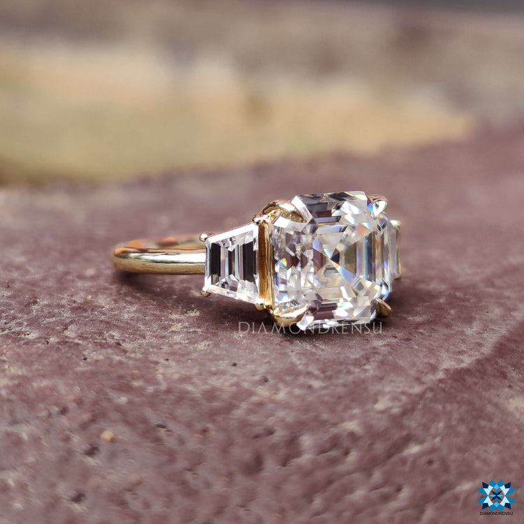 Yellow gold moissanite ring with asscher and trapezoid diamonds.
