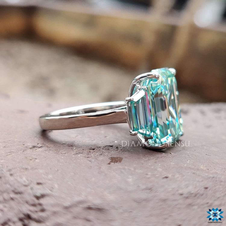 White gold ring with trapezoid cut moissanite side stones.
