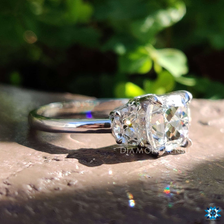 White gold engagement ring with three moissanite stones.

