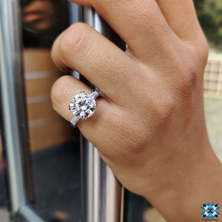 Round moissanite center with tapered baguette side stones.
