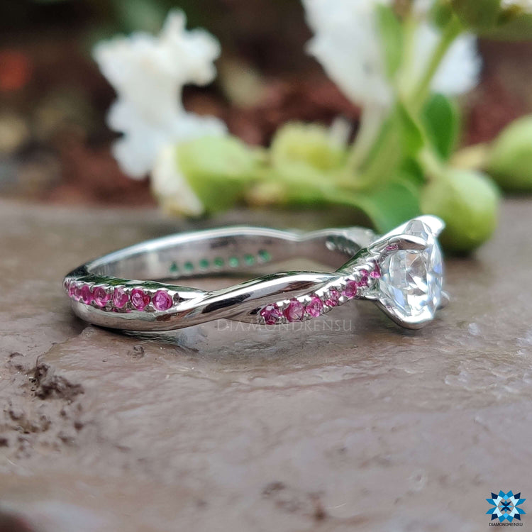 Moissanite engagement ring with emerald and ruby cut stones.
