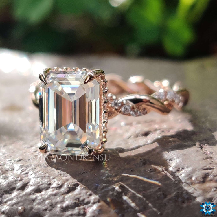 Emerald moissanite ring with round cut side stones.
