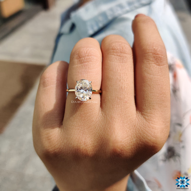Buy engagement ring featuring oval moissanite and hidden round halo.
