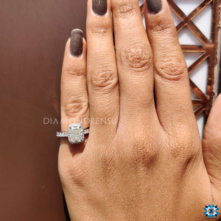 Radiant engagement ring with halo and four prong design.
