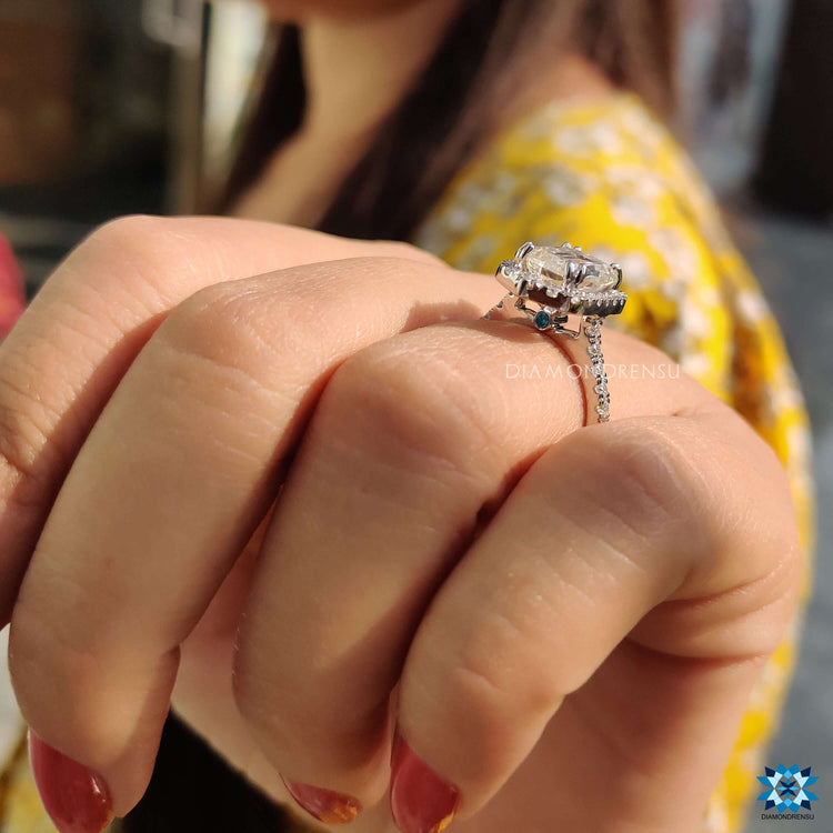 Pave setting ring with blue round moissanite centerpiece.
