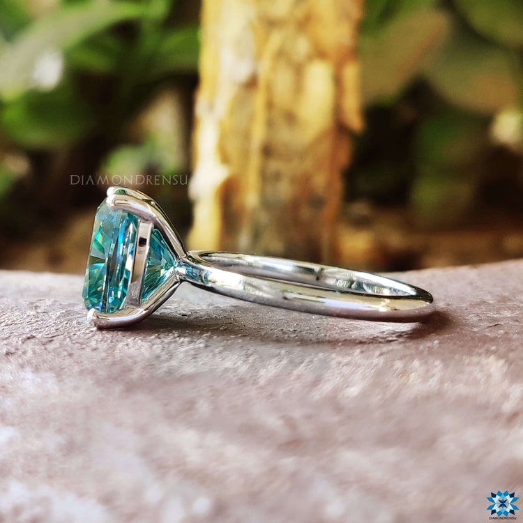 4 prong setting ring featuring blue moissanite.
