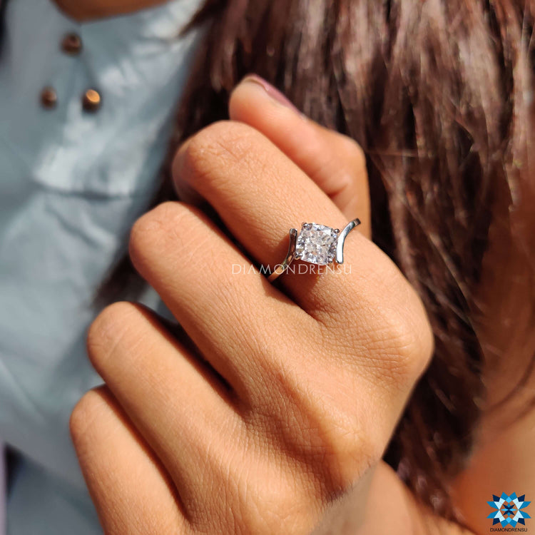 White gold ring with cushion moissanite center stone.
