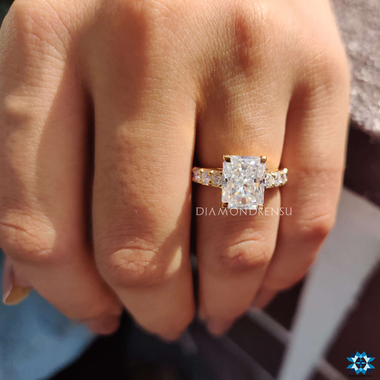 Yellow gold moissanite ring with pave band.
