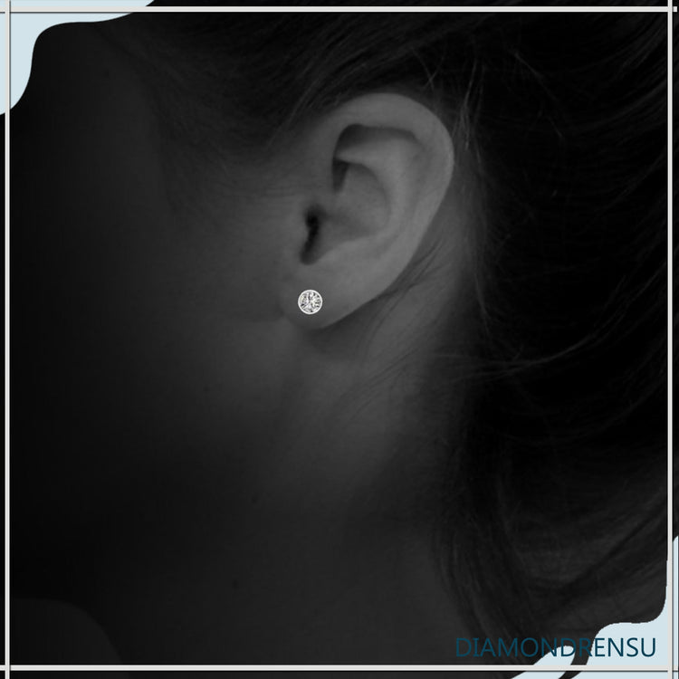 Handmade gold bezel diamond earrings with round cut stones.
