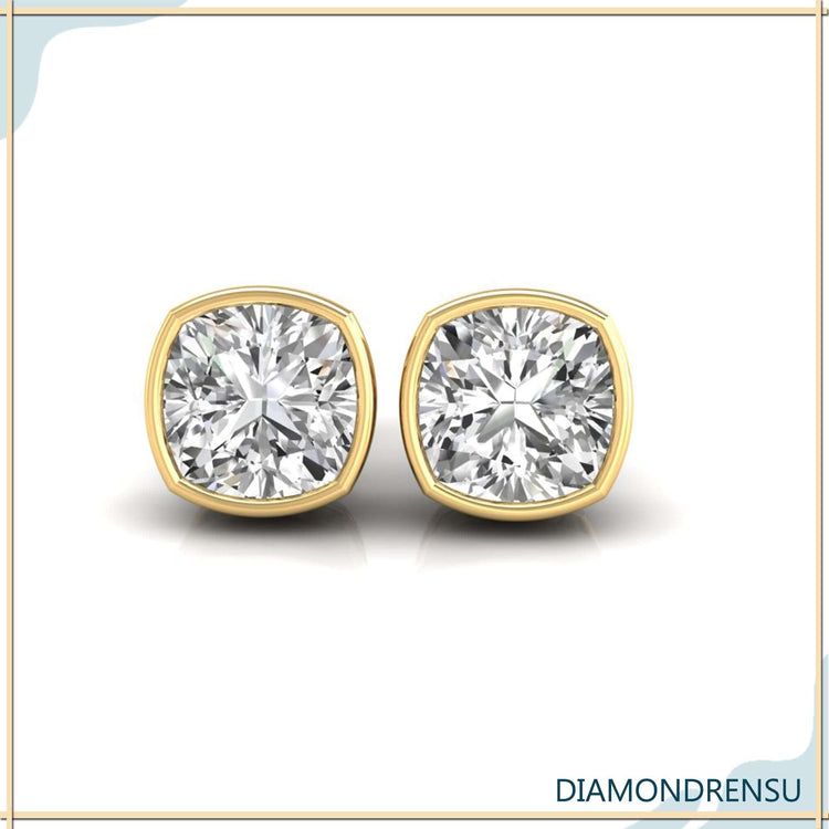 Gold stud earrings with cushion cut bezel set diamonds.
