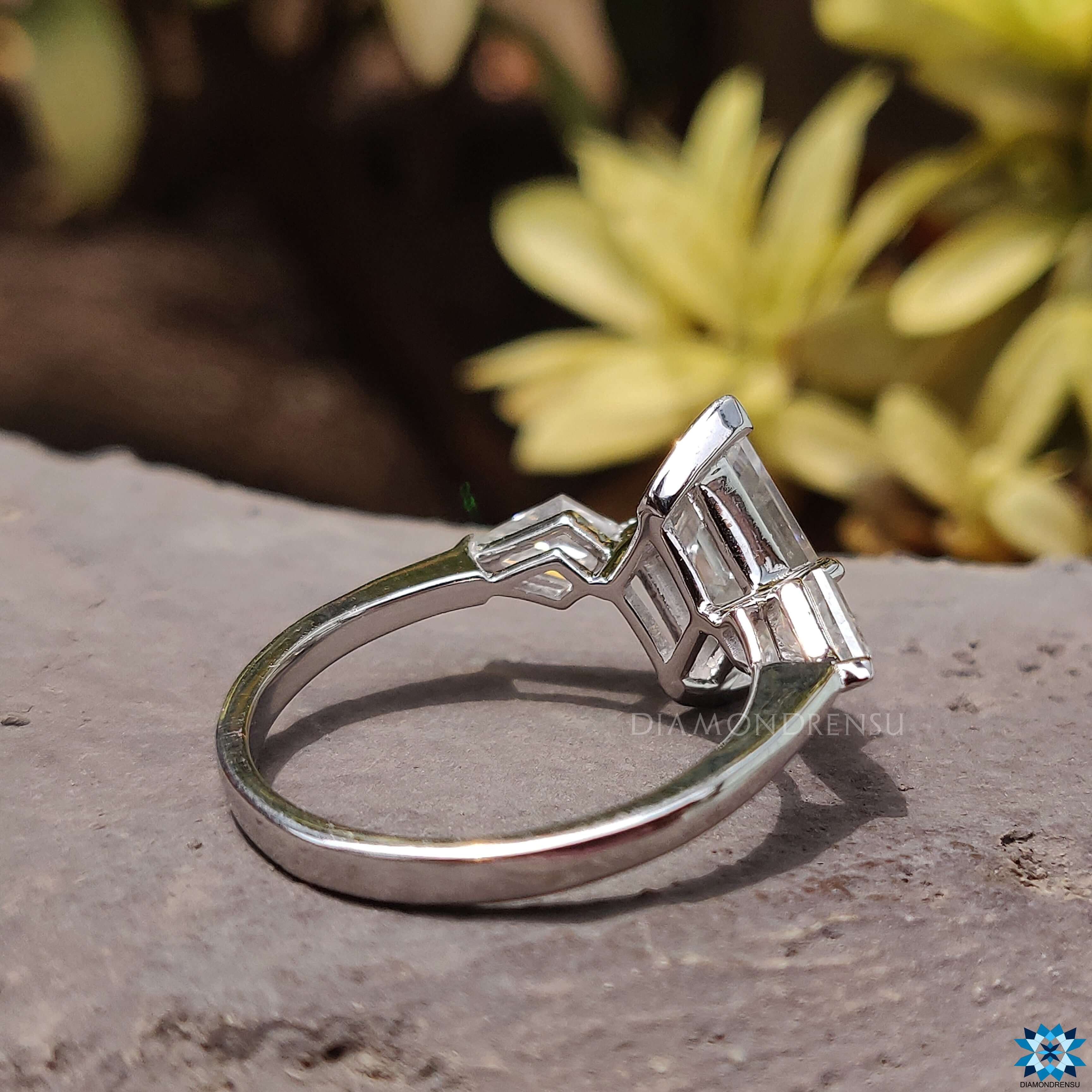 Prong setting ring with 3 stone moissanite and kite cut side stones.