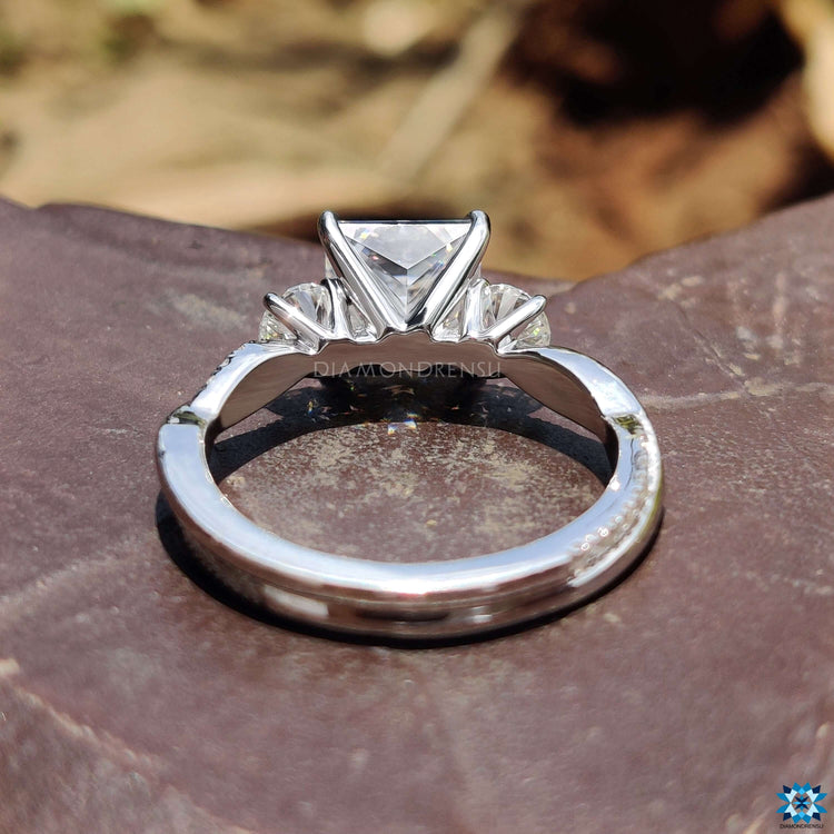 Princess cut center stone with twisted setting.
