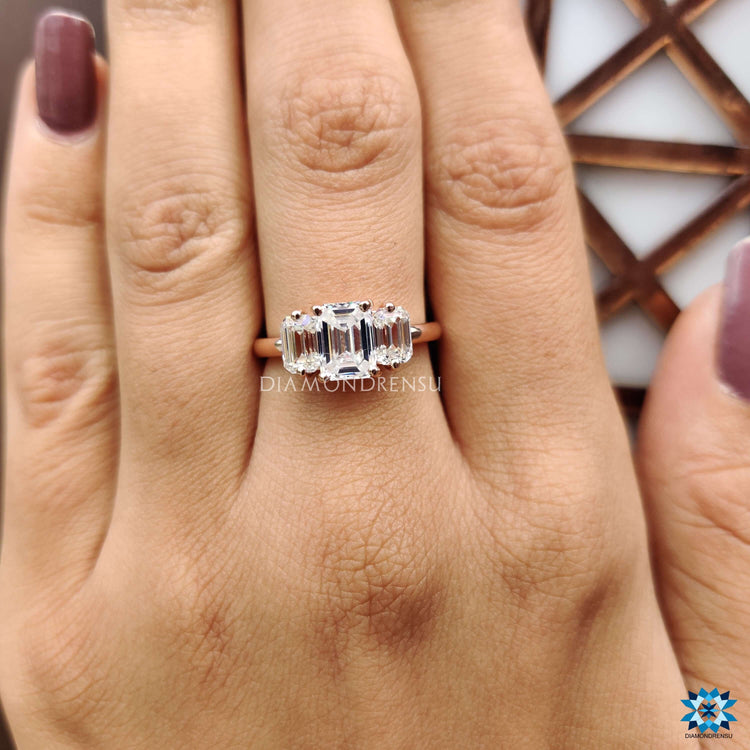 Rose gold engagement ring with emerald cut moissanite.
