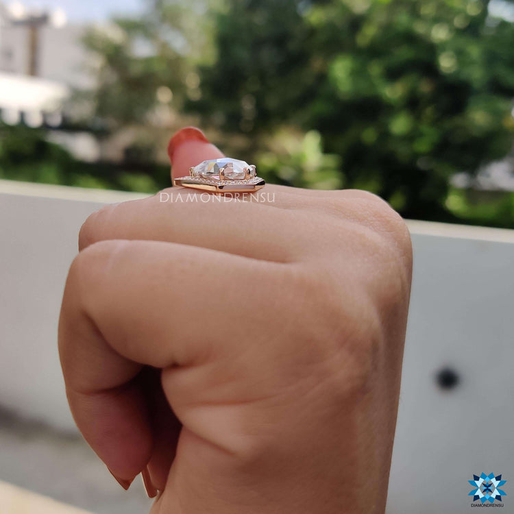 Pear-shaped moissanite ring with halo detail.
