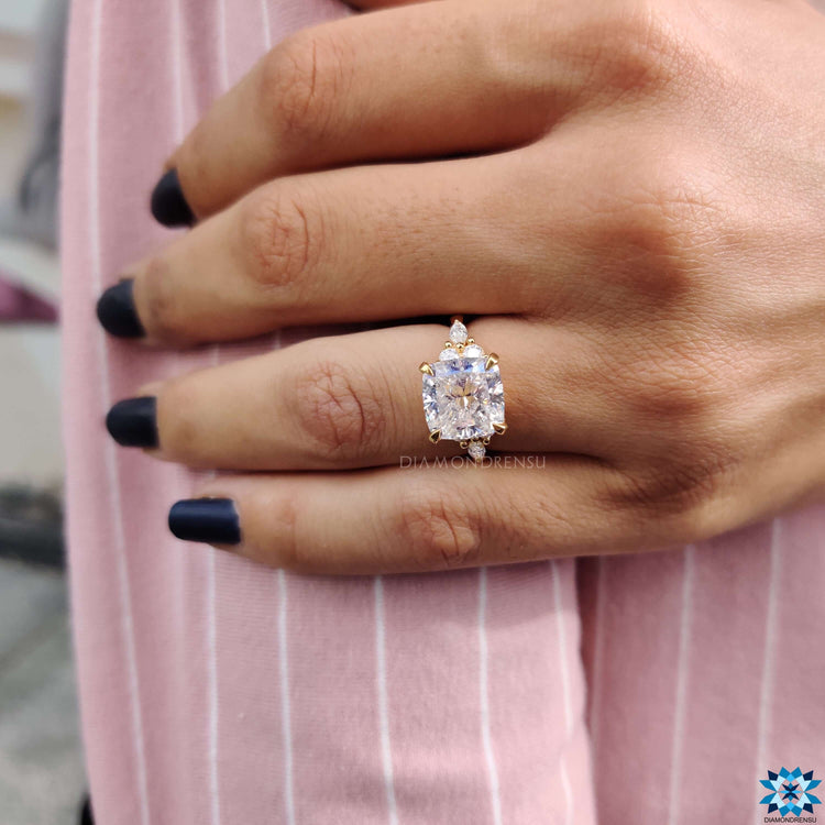 Muse setting cushion moissanite ring with marquise and round side stones.
