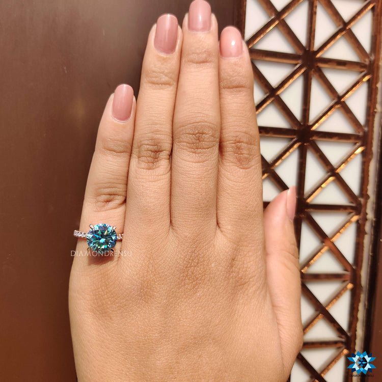 Rose gold engagement ring with round cut moissanite and pave band.
