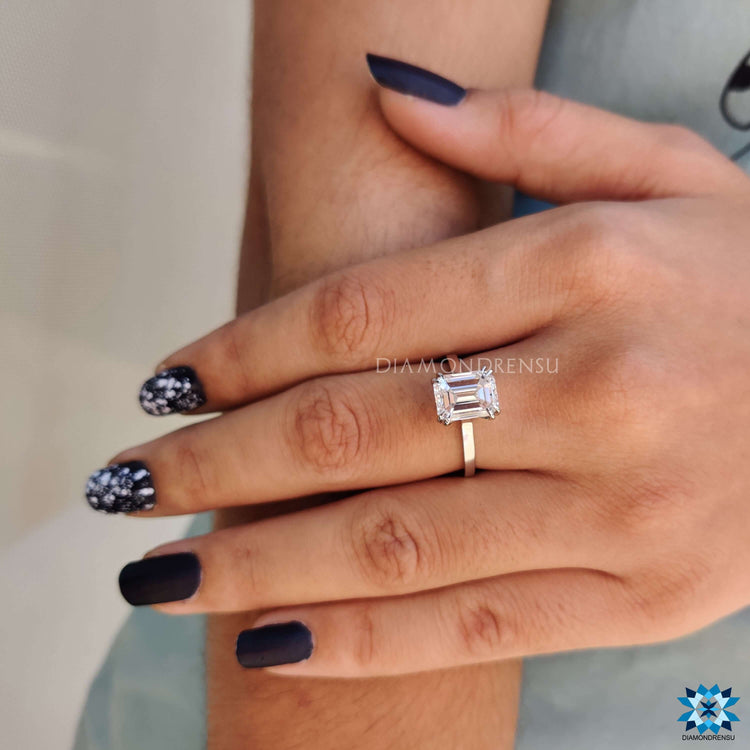 Custom engagement ring with white gold and emerald cut center.
