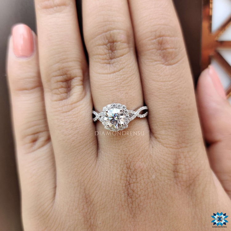 Round moissanite halo ring in white gold setting.

