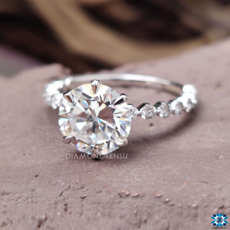 White gold moissanite ring featuring round cut centre and pave details.
