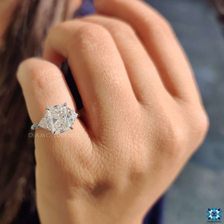 White gold engagement ring featuring radiant center and side trillions.
