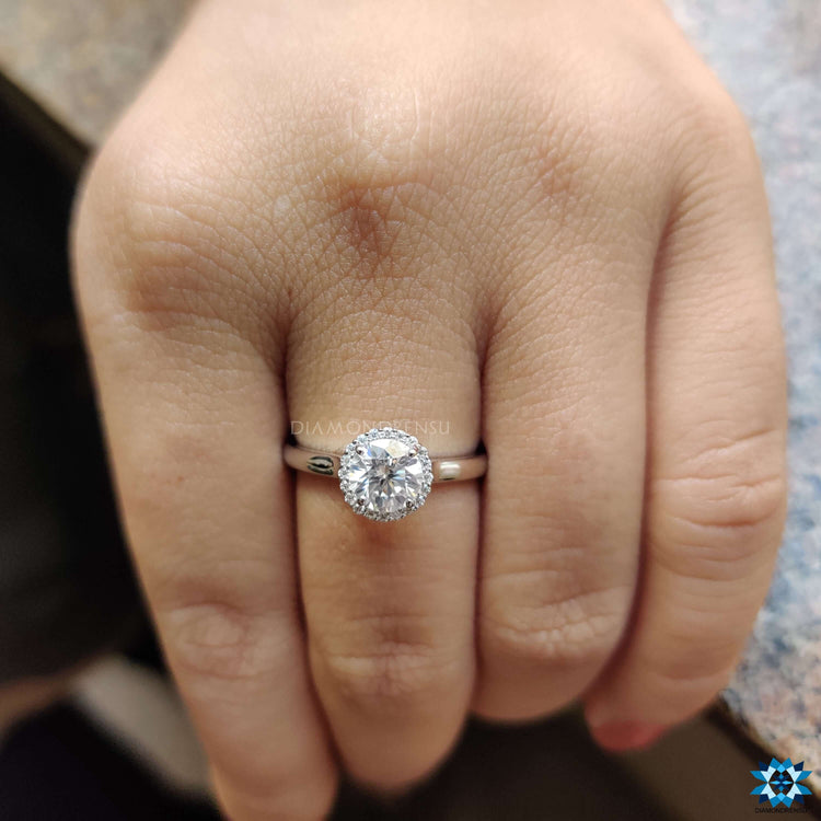 Round cut moissanite ring in a white gold halo setting.
