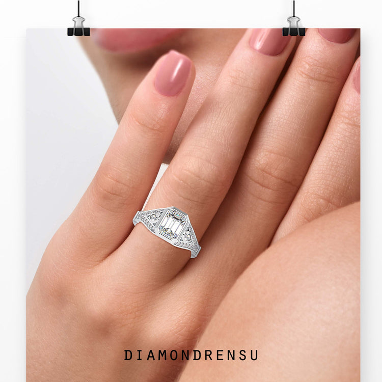 Emerald centre diamond ring in white gold with bezel setting.
