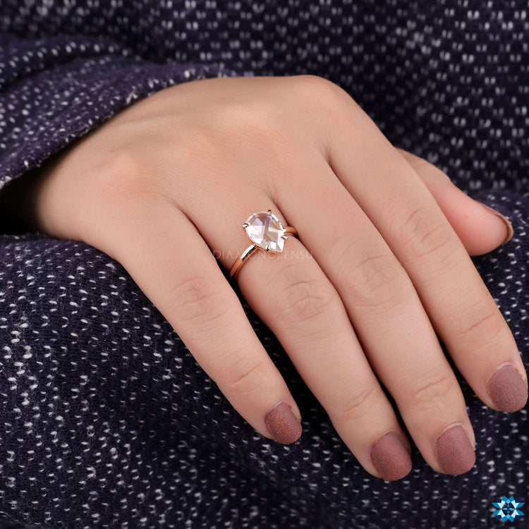 Custom engagement ring with prong setting and pear shape.
