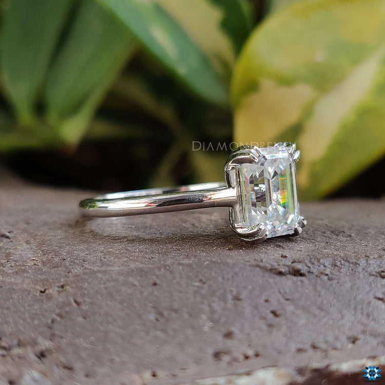 Cathedral setting engagement ring with emerald cut stone.

